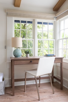 A balcony with wicker furniture and a view of mountains and houses. at Hideaway Santa Barbara, A Kirkwood Collection Property