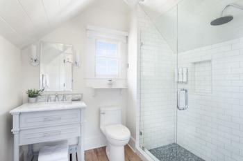 A kitchen with a white countertop, a blue cabinet with glass doors, and a white door with a view of the outside. at Hideaway Santa Barbara, A Kirkwood Collection Property
