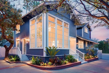 A wooden desk with a lamp, a chair, and a window with blinds. at Hideaway Santa Barbara, A Kirkwood Collection Property