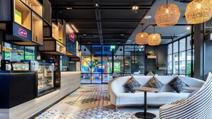 Een modern interieur met een receptiebalie, een witte bank en een vloer met een patroon.