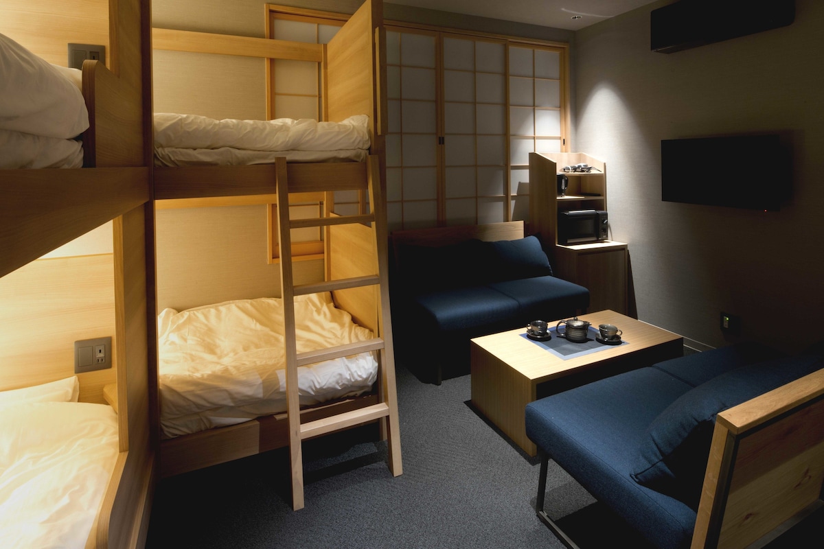 Een slaapkamer met een stapelbed, een bureau en een bank.