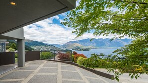 Una terraza con vistas a montañas y un lago.