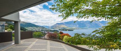 A terrace with a view of mountains and a lake.