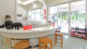 A reception area with a white counter, a mirror, and a '2 PM Check-in' sign.