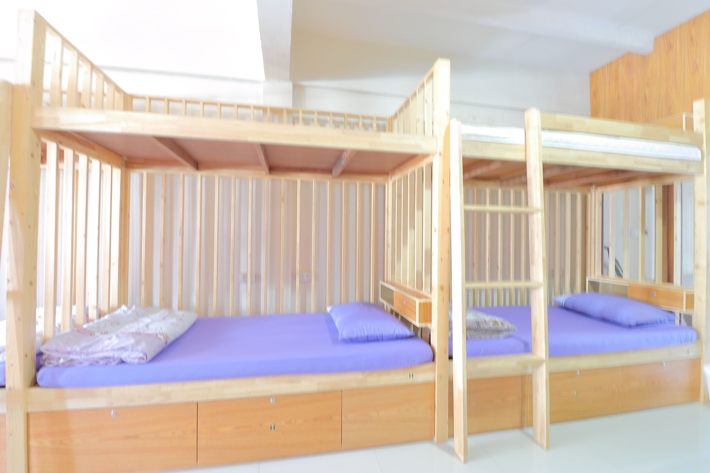 A bunk bed with two levels, each with a wooden frame and a mattress.