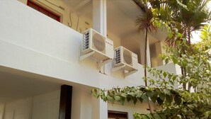 Een gebouw met twee airconditioners met daarop de tekst 'SINGER'.