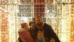 Una famiglia di cinque persone davanti a un'illuminazione decorativa.