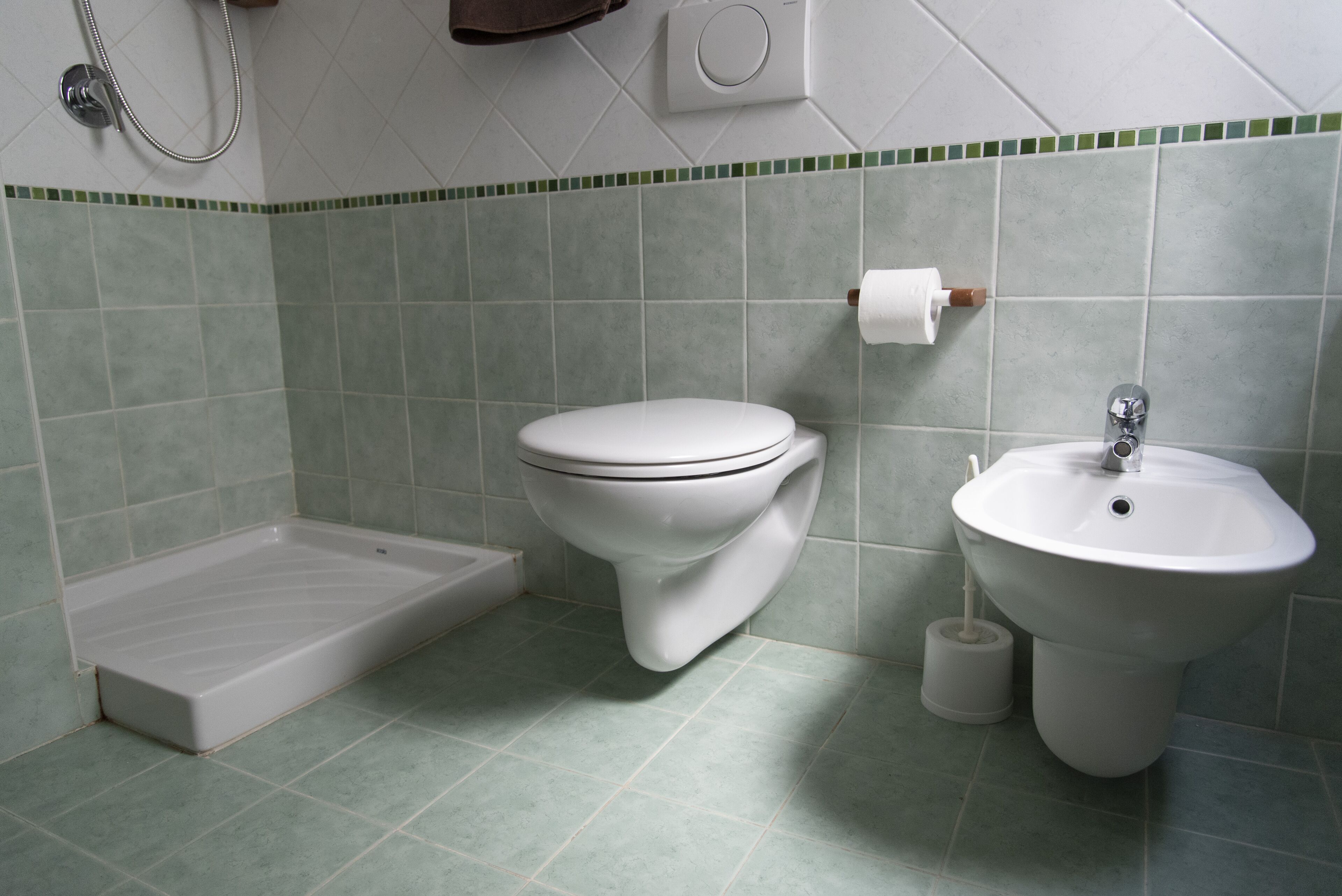 A bathroom with a toilet, sink, and shower.