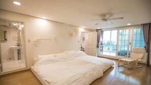A spacious bedroom with a large bed, a ceiling fan, a window with a view, and a bathroom with a shower. - SG Tailored Serviced Home 5min walk from metro (Seoul)