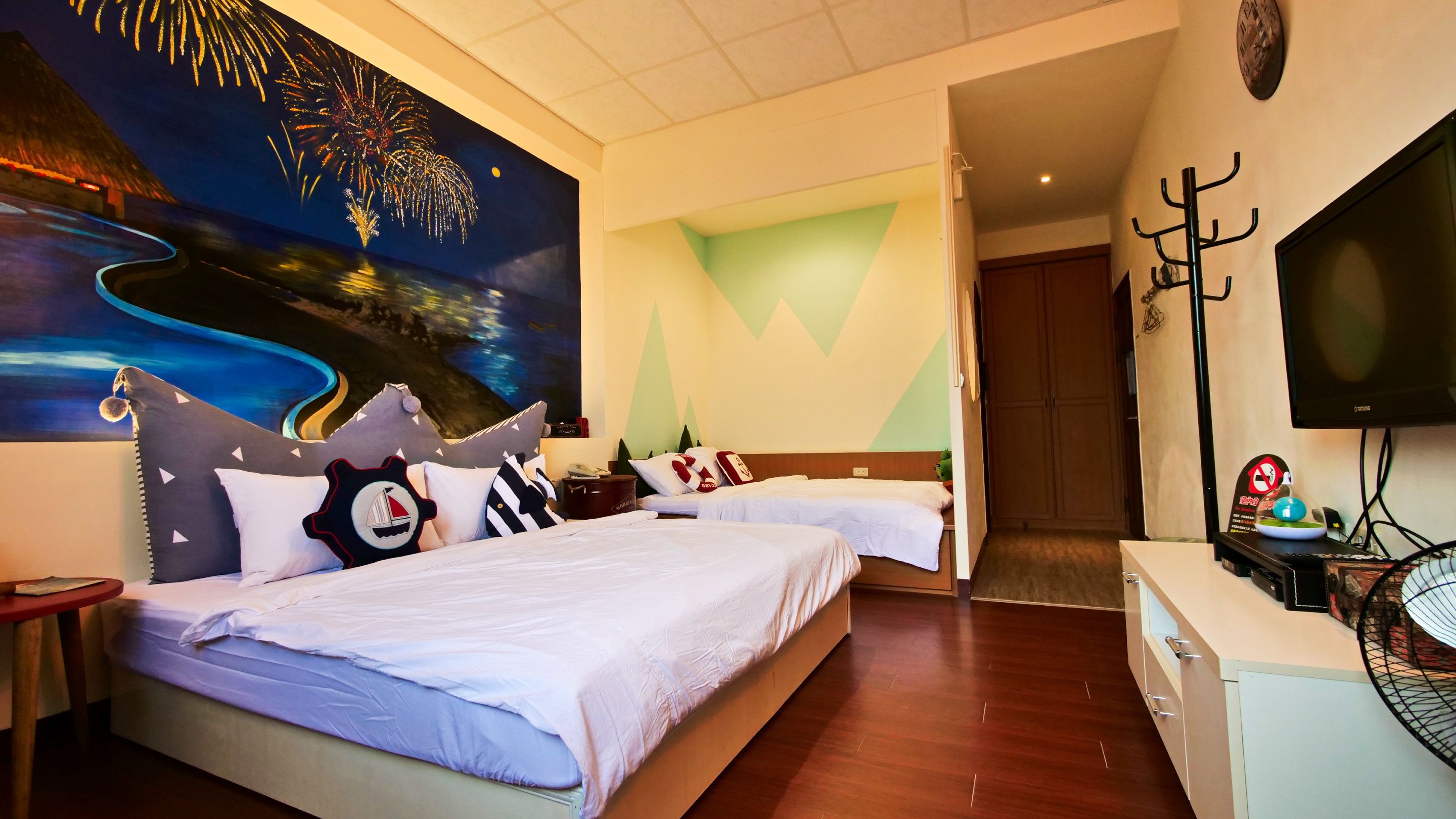 Una habitación de hotel con una cama, televisión, escritorio y un cuadro en la pared.