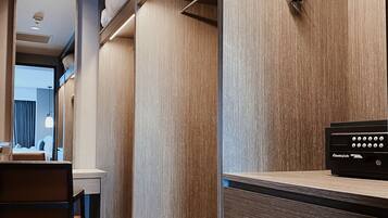 Een moderne hotelkamer met een houten inrichting, een bureau met stoel en een bed met hoofdeinde.