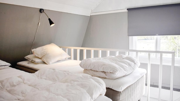 A bedroom with two beds, a bedside table, a lamp, and a window with a blind. - 2 bedroom gorgeous home in Jämjö (Jämjö)