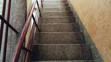 Una escalera con barandilla metálica que lleva a un espacio exterior.