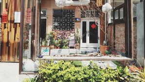 A storefront with a wooden facade, a glass display window, and a metal gate. - GOIN Old House & Bar (Tainan)