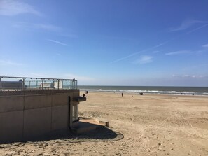 A beach with a concrete structure, possibly a lifeguard tower, and a clear sky.