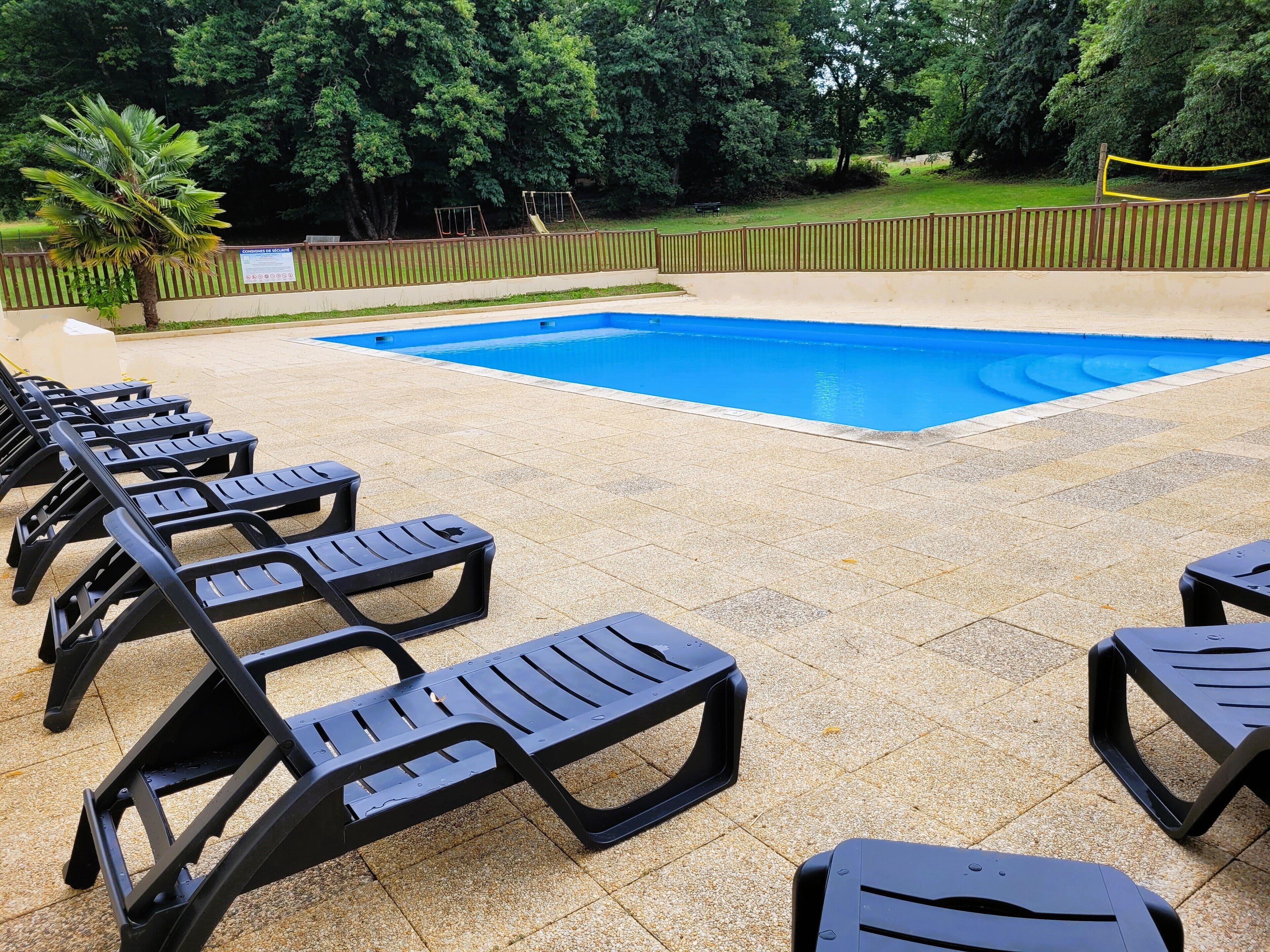 A swimming pool with lounge chairs arranged around it.