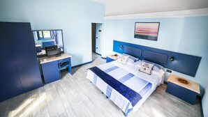 Ein modernes Hotelzimmer mit einem großen Bett, einem Schreibtisch und einem Kleiderschrank.