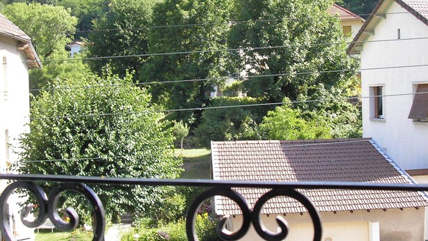 Un quartier résidentiel avec des maisons, une voiture et une colline en arrière-plan.