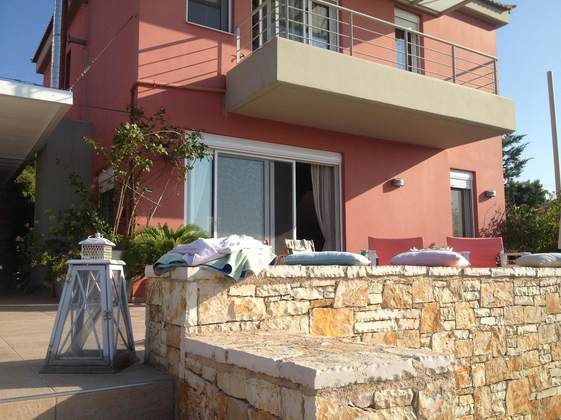 A two-story building with a balcony, stone wall, and a white lantern.