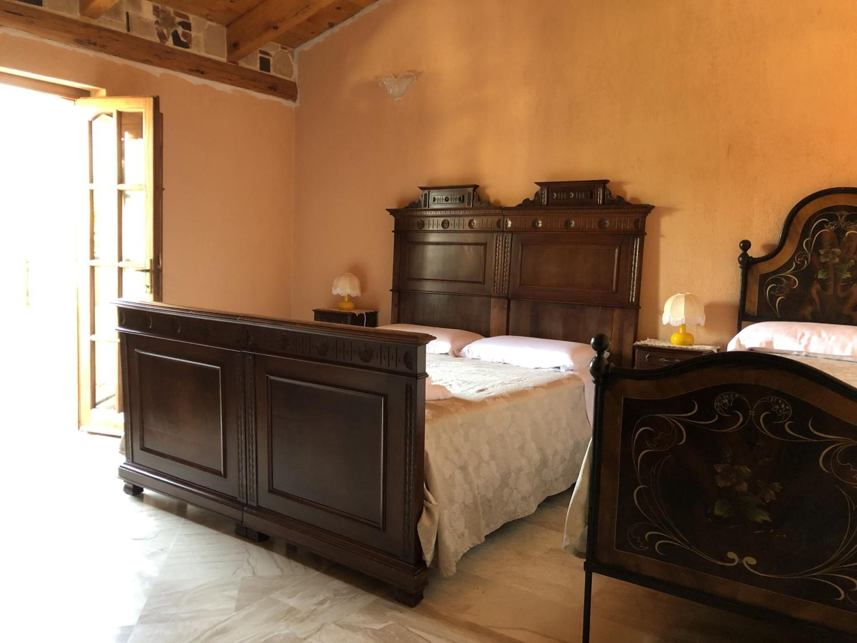 Une chambre à coucher avec un grand lit en bois, une table de chevet et une commode.
