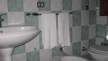 A bathroom with a sink, bidet, and toilet.
