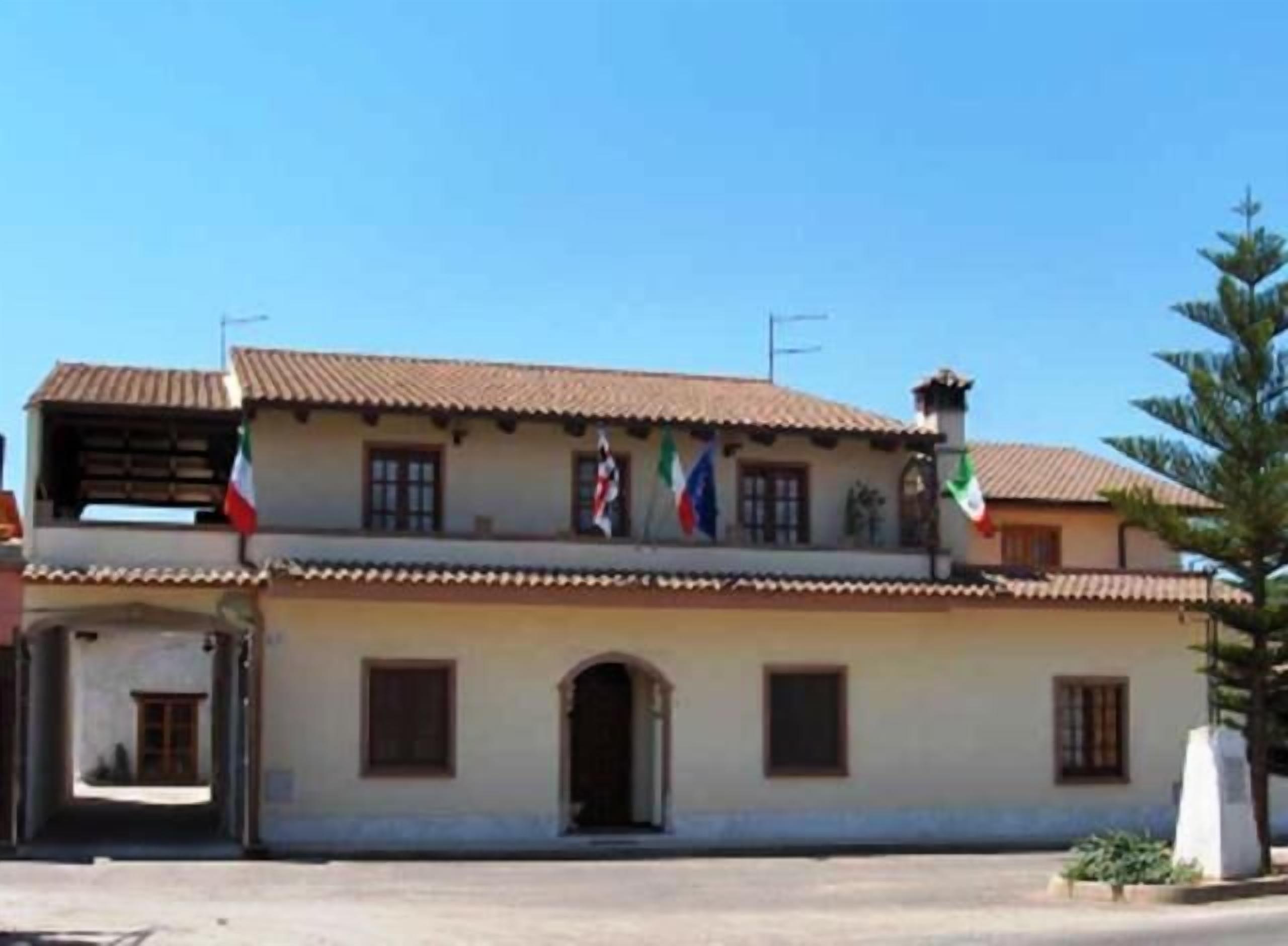 Un edificio a due piani con tetto in tegole e diverse finestre.