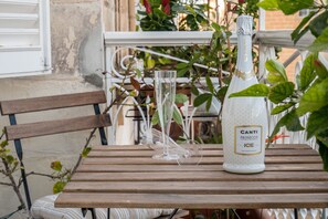 Uma garrafa de Canti Prosecco ICE sobre uma mesa de madeira, com uma taça de vidro transparente.