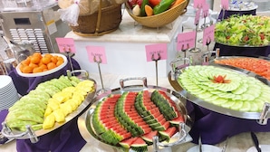 A buffet with various food items including fruits and salads.