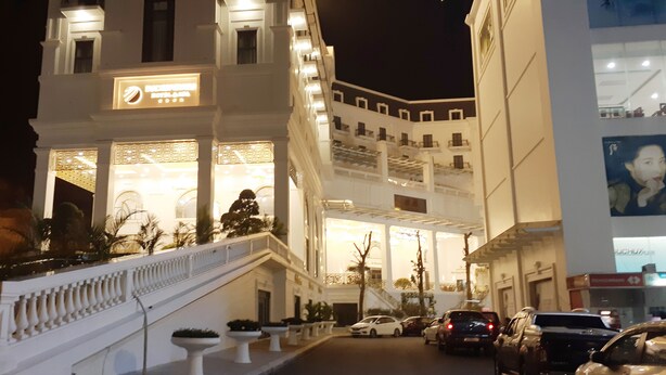 A hotel with a grand entrance, multiple floors, and a well-lit facade.