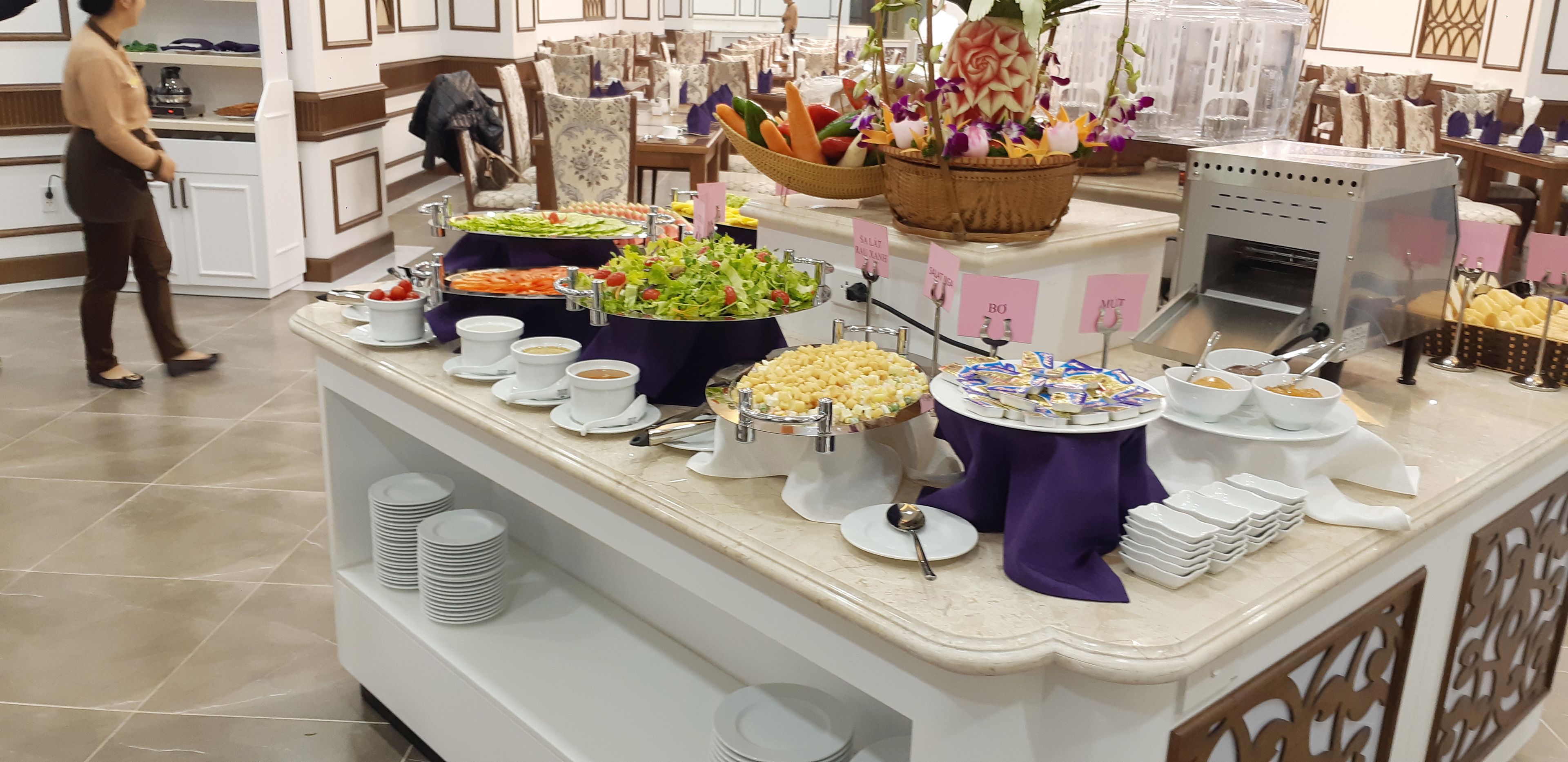 A buffet setup with various food items and a salad bar.