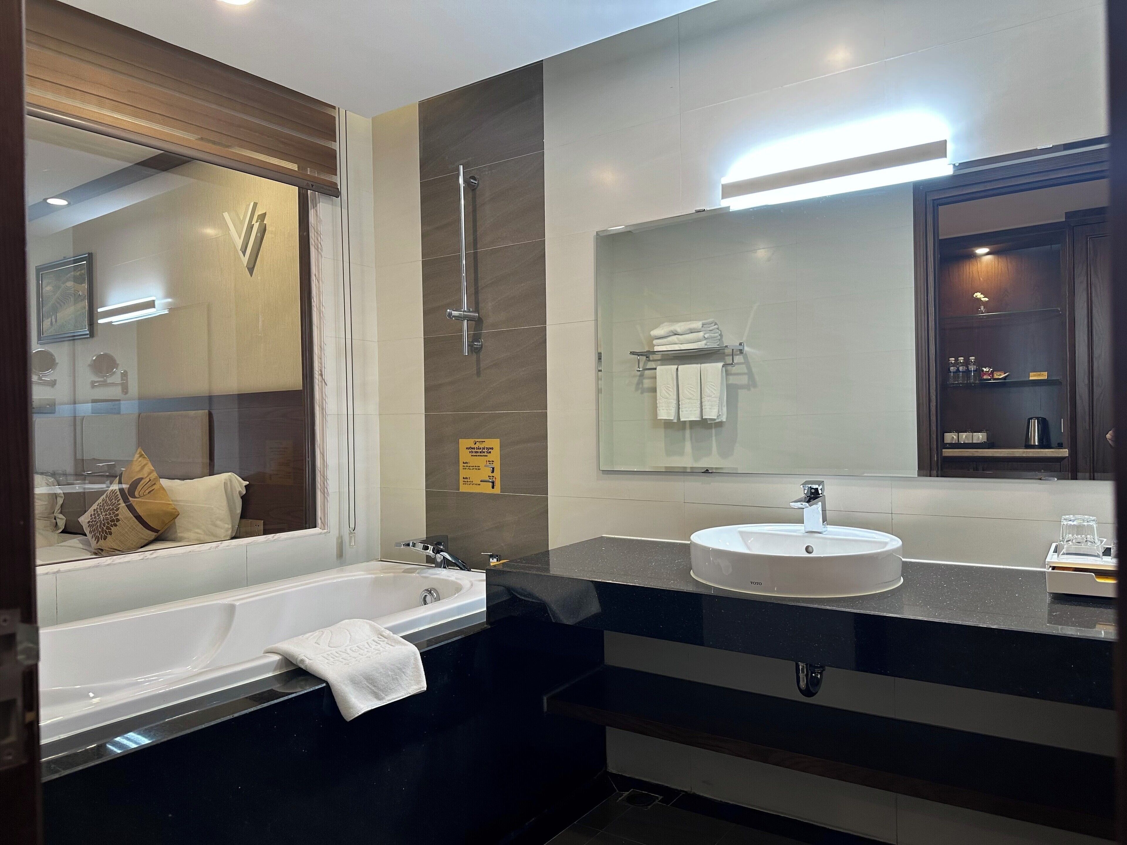 A modern bathroom with a bathtub, a sink, and a large mirror.