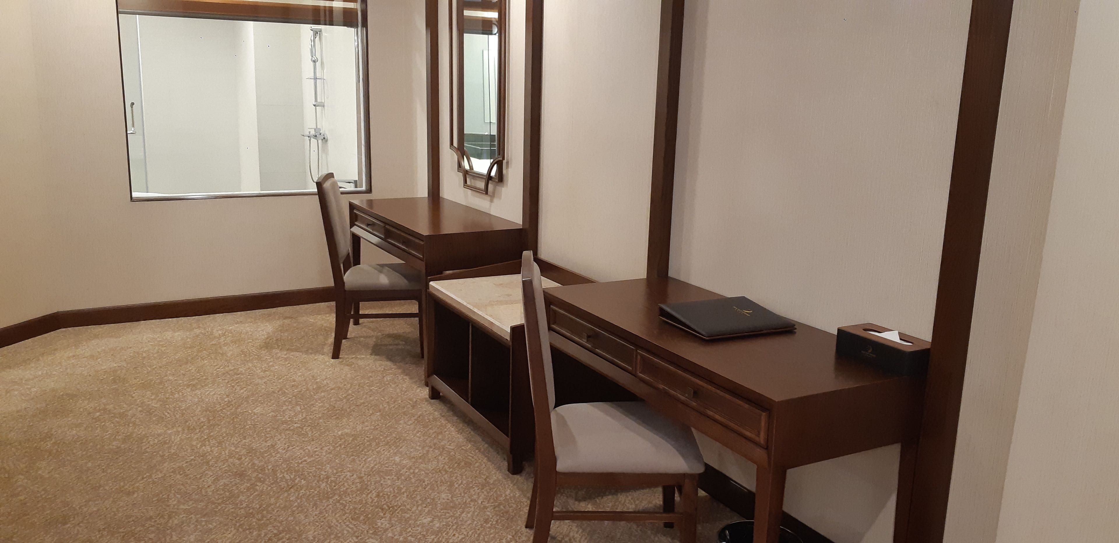Un petit bureau privé, équipé d’un bureau, d’une chaise et d’une fenêtre.