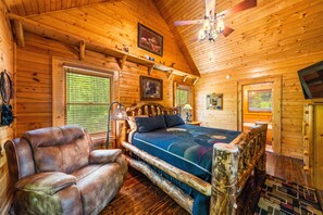 Relax in this charming room with a large bed, leather armchair, and wooden bench.