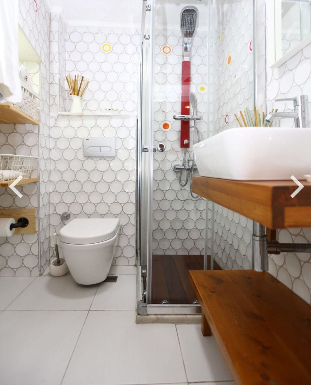 A bathroom with a toilet, shower, and sink.