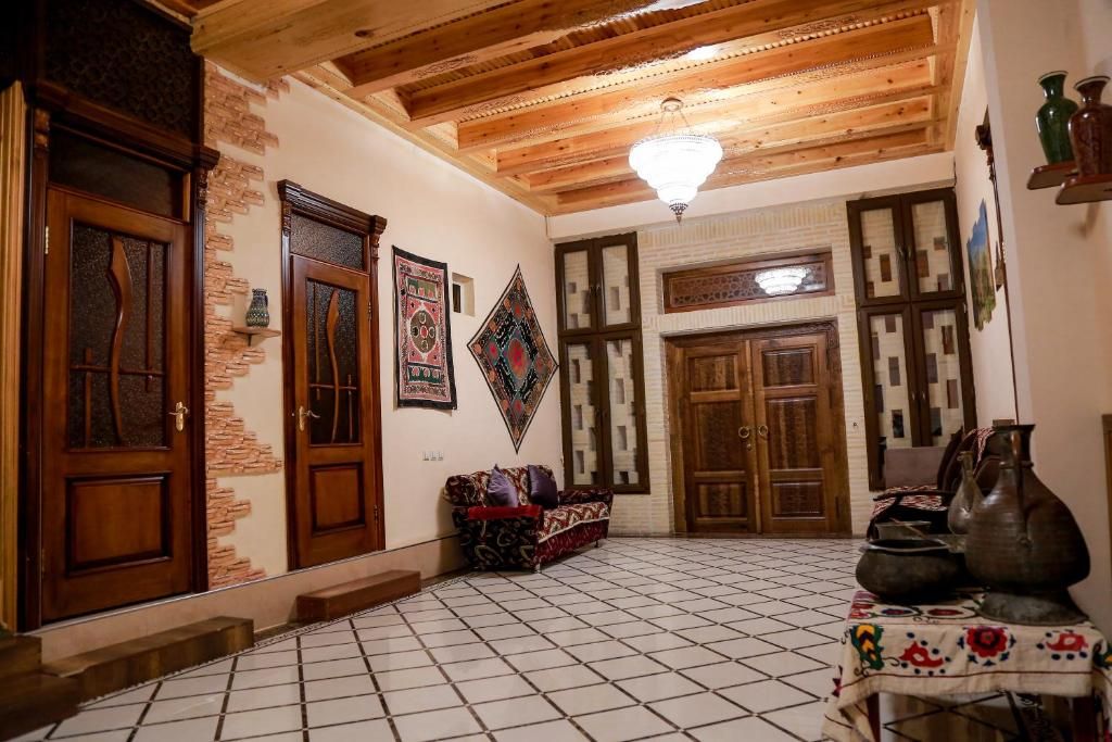 A traditional interior with wooden doors, a tiled floor, and a patterned wall.