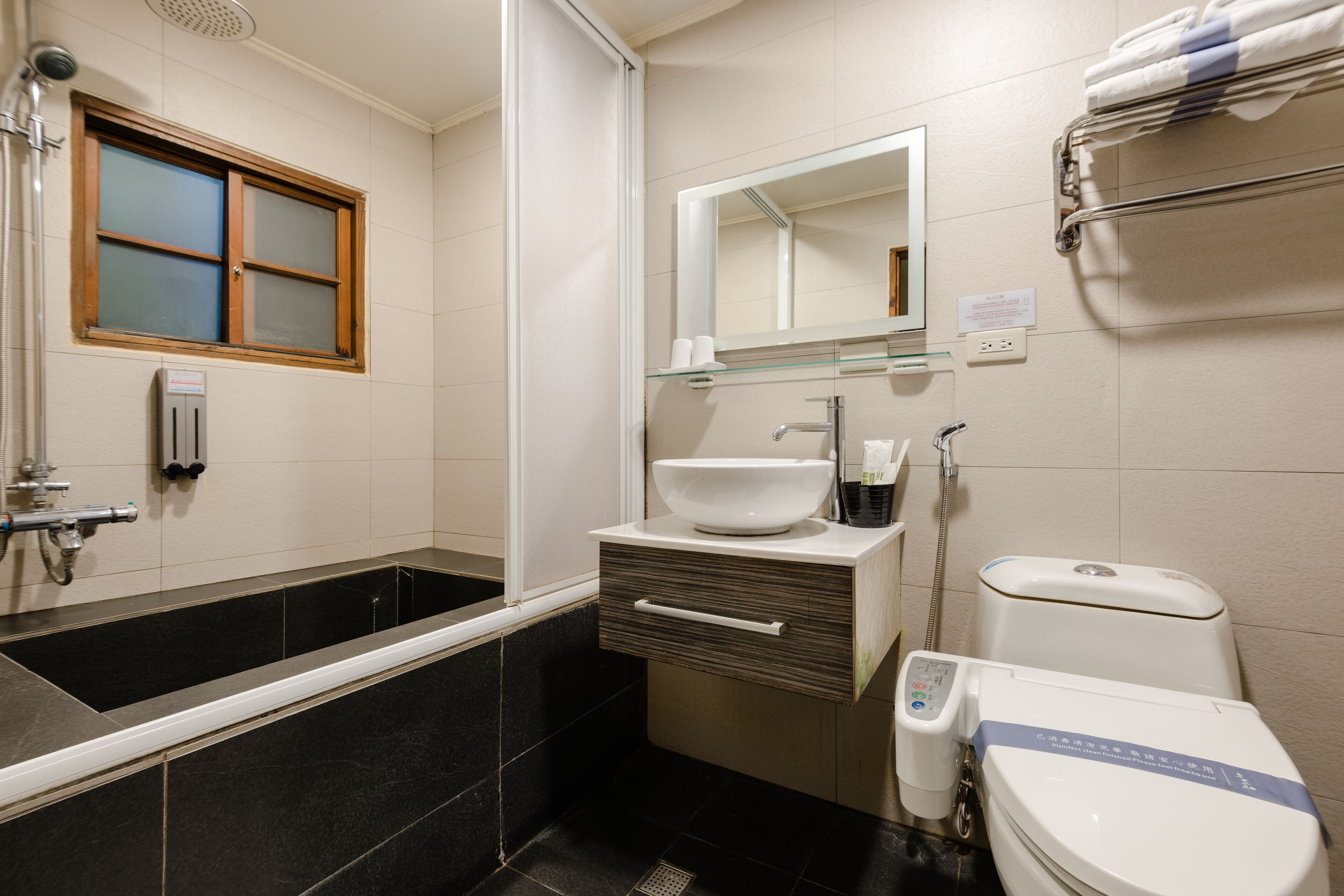 A modern bathroom with a bathtub, a sink, a toilet, and a shower.