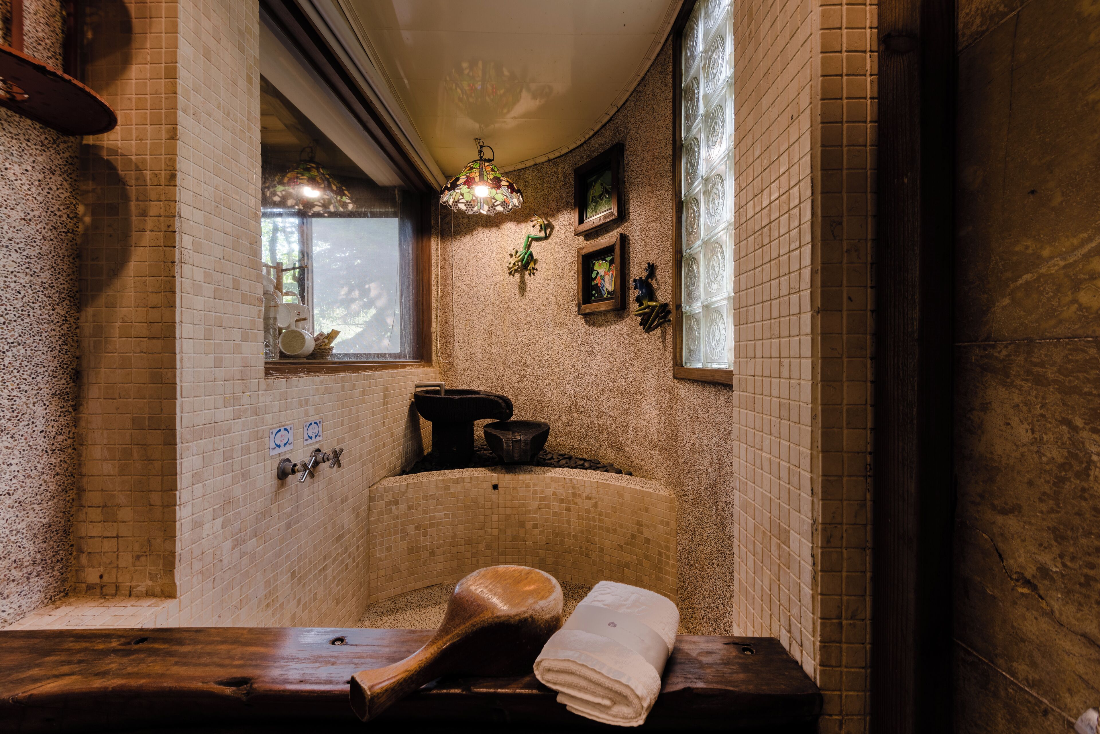 A traditional Japanese-style bathroom with a wooden bench, a towel, and a decorative hanging lamp.