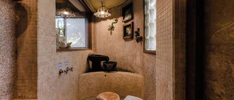 A traditional Japanese-style bathroom with a wooden bench, a towel, and a decorative hanging lamp.