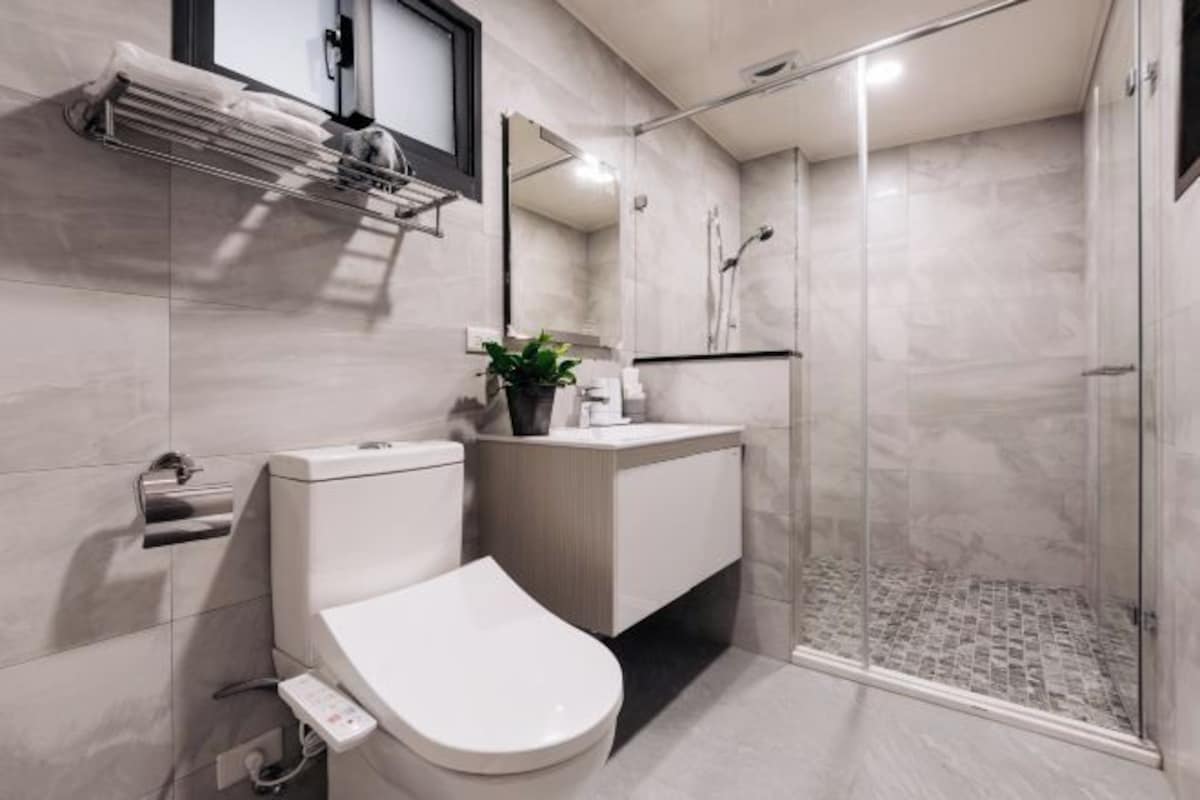 A modern bathroom with a toilet, sink, and shower.