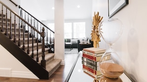 A staircase with wooden balusters, a glass table with books and an hourglass, and a framed picture on the wall. - Large Home, 4 bds, 3.5 bths, complete remodeled: luxurious amenities..see pics (Cottonwood Heights)