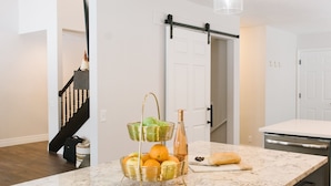 A kitchen with a marble countertop, dark cabinets, and pendant lights. - Large Home, 4 bds, 3.5 bths, complete remodeled: luxurious amenities..see pics (Cottonwood Heights)