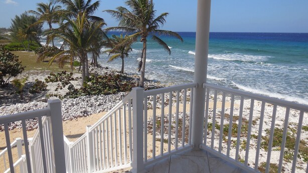 A balcony with a view of the beach and ocean. - RazorBrac SeaEsta - Private Beachfront Home (Cayman Brac)