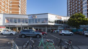 A street view with a building labeled "Evite" and parked bicycles. - Shopping Centre and Cinema Atmosphere (London)