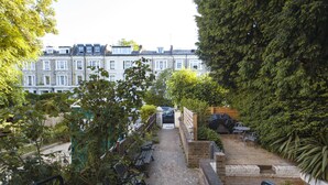 A pathway leading to a row of terraced houses with a bench and a table on the right. - Shopping Centre and Cinema Atmosphere (London)