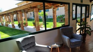 Ein Balkon mit zwei Sesseln, einem kleinen Tisch und einem Blumentopf.