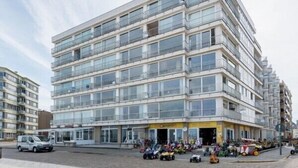 Un hotel de varios pisos con un diseño moderno, que cuenta con balcones y ventanas amplias.
