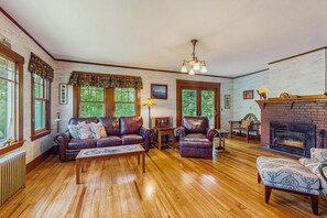 Relax in this traditional living room with a leather sofa, armchair, and brick fireplace.