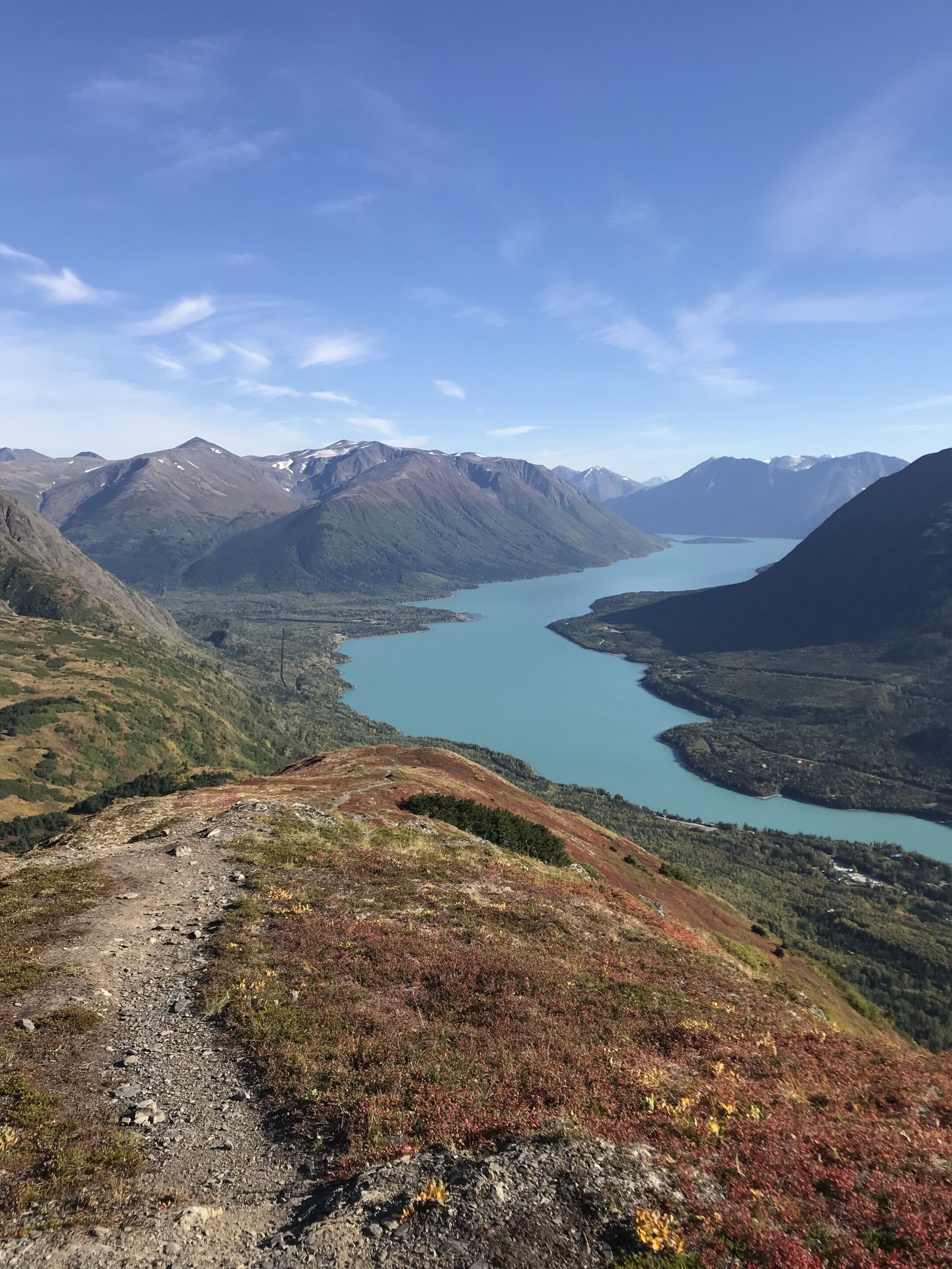 A mountainous landscape with a clear blue lake and a rocky path.