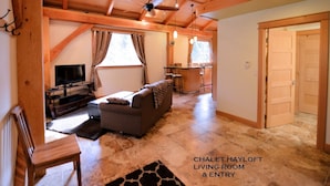 Salón comedor en un granero chalet con sofá, televisor y zona de comedor.