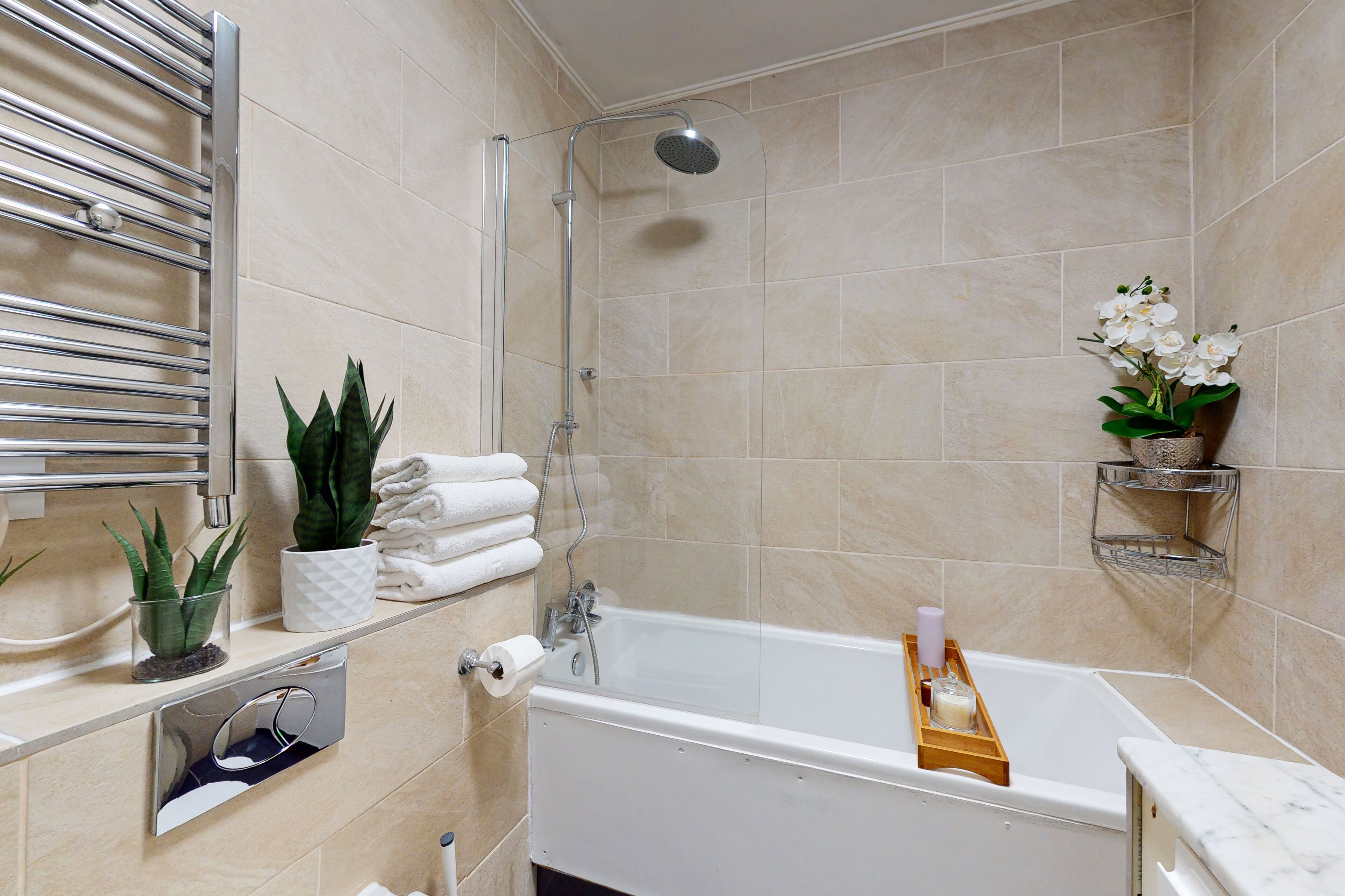 Un bagno moderno con vasca, doccia e diversi articoli da toilette.